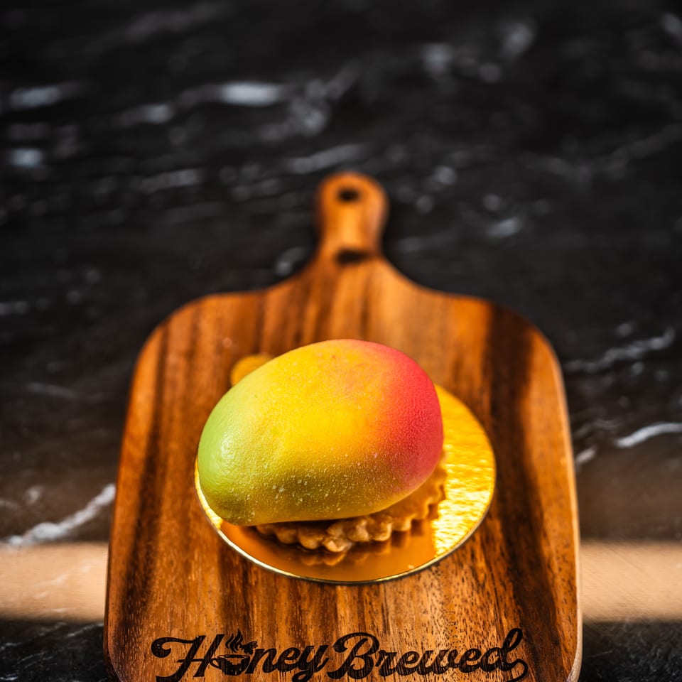 Colorful mango dessert served on a wooden plate at Zafiro’s Bakery Café.
